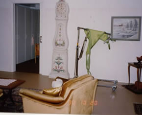 写真�C：先祖伝来の家具で飾られた居間、ホームヘルパーの腰痛防止のためのリフトも見えます。